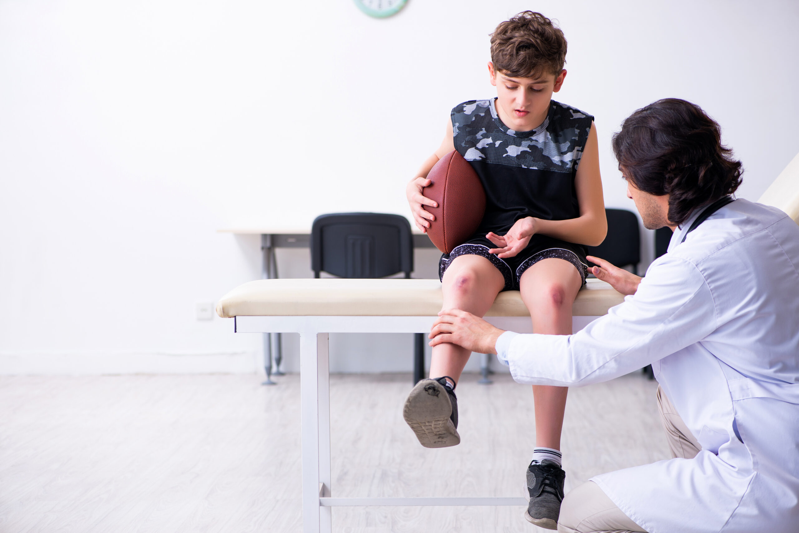 Young football player visits the orthopedic doctor's office after facing an injury.